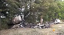Photo des débris de l'avion, ici quelques débris carbonisés restant après l'incendie ayant résulté de l'accident.