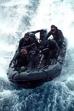 Des SEAL de la Team Five en exercice à bord d'un canot pneumatique — Combat Rubber Raiding Craft (en) — en 2000.