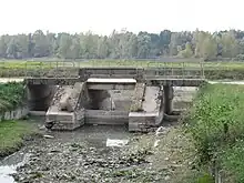 Le débouché de la Bionne (au premier plan) dans le canal d'Orléans (derrière la passerelle), à Combleux, lors d'une vidange du canal