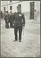 Photographie en noir et blanc d'un homme, de pied, en tenu militaire, portant le képi.