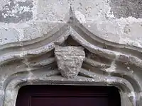 Détail linteau en accolade avec un blason au chef de l'Ordre.