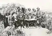 Essad Pacha (à dr. de la table) entouré d'officiers allemands et ottomans (dont Mustafa Kemal) sur le front des Dardanelles en 1915