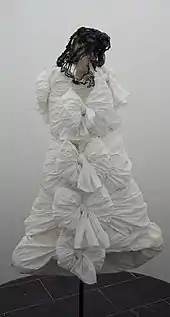 Une robe blanche exposée dans un musée sur mannequin.