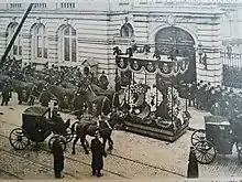 le char funèbre tiré par des chevaux caparaçonnés de deuil stationne devant le palais du comte de Flandre en attendant que l'on y dépose son corps