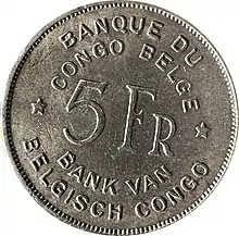 Une pièce ronde argentée portant les mentions « Banque du Congo belge. 5 Fr. Bank van Belgisch Congo. »