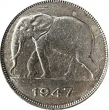Une pièce ronde argentée avec le dessin d'un éléphant et la date 1947.