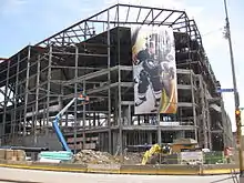 Photo de la structure du Consol Energy Center pendant sa construction ; une affiche géante représentant Sidney Crosby y est accrochée.