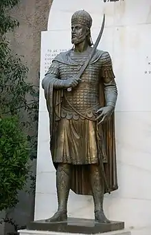 Photographie de la statue d'un homme tenant une épée.