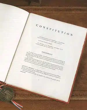 Vue d'une page d'un livre, avec le mot Constitution en titre.