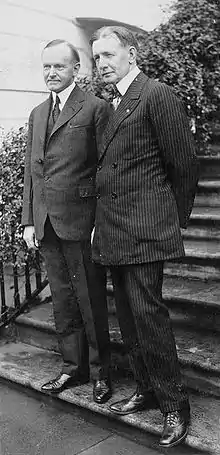 Deux hommes en costume sur les premières marches d'un escalier