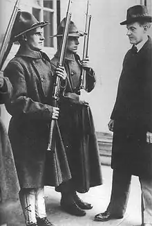 Photographie de Coolidge examinant plusieurs soldats en uniforme au garde-à-vous avec leurs fusils