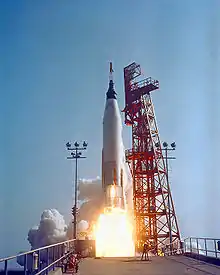 Une fusée au décollage, flammes visibles à l'arrière.