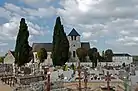 Photographie en couleurs d'une église en arrière-plan d'un cimetière.