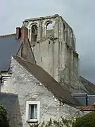 Photographie en couleurs d'en ancien clocher auquel est accolé une tourelle semi-cylindrique.