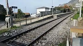 Vue d'ensemble de la gare avec le quai et la voie.