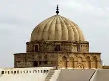 Photographie montrant un gros plan extérieur de la coupole du mihrab. Le dôme, légèrement pointu, est côtelé de godrons en pierre de taille ; il repose sur un tambour octogonal, percé de huit fenêtres rectangulaires.