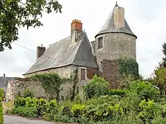 Photographie en couleurs d'une tour ronde à l'angle d'un grand bâtiment.