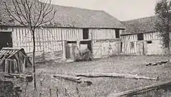Photographie en noir et blanc d'une ferme et de sa cour.