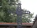 Détail de la croix, en bas un triangle symbole de la trinité, au centre de la croix, Saint-Joseph offrant un bouquet de fleurs à Marie