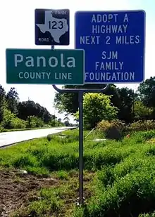 Vue de trois panneaux de signalisation dont l'un annonçant l'entrée dans le comté.