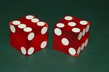 Dés cubiques utilisé au craps (jeu d’argent dans les casinos).À la différence des dés traditionnels, les points ne sont pas gravés sur les dés, mais imprimés pour respecter l'équilibre (équiprobabilité).
