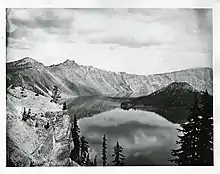Photo en noir et blanc d'une partie de la caldeira, avec le lac et une île volcanique en son sein.