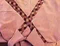 Enrouler la cravate autour du col. Croiser la bande large au-dessus du petit bout au niveau de la couture (cf image en taille réelle).