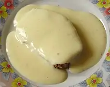 Crème anglaise nappant une tranche de pain d'épices.