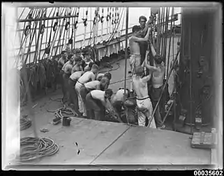 Le travail des gabiers s'effectue aussi au hissage sur le pont, ici sur le quatre-mâts barque Magdalene Vinnen en 1933, transportant de la laine à destination de l'Australie.