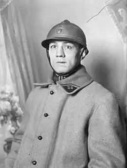 Portrait d'un homme, yeux écarquillés, mâchoire abîmée, en tenue militaire avec un casque sur la tête.