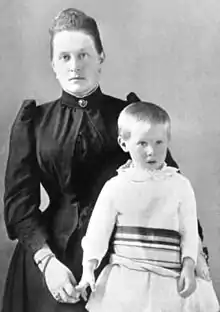 Photo en noir et blanc d'une femme vêtue de noir et d'un petit garçon.