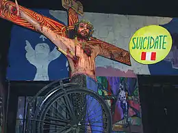  Photo montrant une crucifixion de Jésus qui porte des banderilles, au-dessus de sa tête se trouve un panneau.
