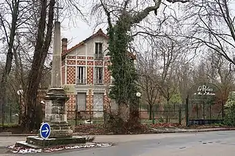 La croix et l'ancien restaurant Le Relais du bois de Boulogne.