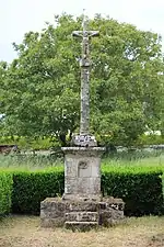 Croix de Ténuel en France composée d'un soubassement évidé d'une niche, un socle à sommet hémisphérique et une croix séparée du fût écoté par un nœud-boule.