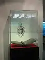 Vitrine avec un metate et une sorte de mortier utilisés pour moudre le grain. Le dessin ci-dessus illustre la façon d’utiliser cet outil.