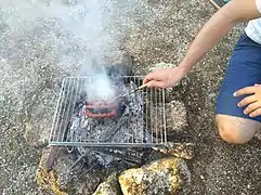 Barbecue artisanal, fait de pierres et d'une grille.