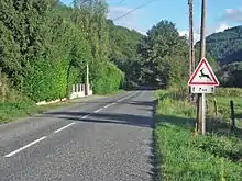 Une route avec, à droite de la photo, le panneau A15b et le panonceau M2