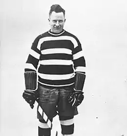 Photographie en noir et blanc de Denneny en tenue de joueu de hockey