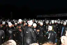 Photo triathlètes en combinaison de natation pour un départ de nuit