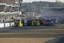 Vue de face du départ d'une course de camions sur le circuit des 24 heures du Mans