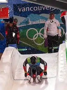 Photographie d'un lugeur poussant sur ses bras pour prendre le départ.