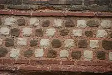 série de blocs de pierres en forme de lignes obliques de part et d'autre de briques.