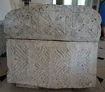 Photographie en couleurs d'un sarcophage en pierre.