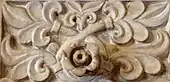 Photographie montrant des détails décoratifs d'un panneau sculpté en marbre blanc de la paroi du mihrab.
