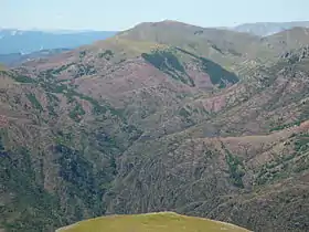 Vue du dôme de Barrot avec sa masse de 900 m d'épaisseur de pélites rouges du Permien entamées ici par le ruisseau de Raton, affluent de rive ouest du Cians.