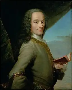 Peinture de Voltaire de trois quart, souriant et tenant un livre dans la main gauche.