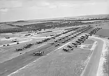 Photo aérienne noire et blanc d'avions sur une piste.