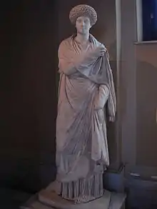 statue féminine en marbre : elle est en toge, avec une coiffure élaborée