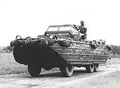"photo noir et blanc d’un grand véhicule amphibie mililre sur une route"
