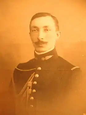 Portrait d'un jeune homme en buste, en tenue militaire avec fines moustaches.